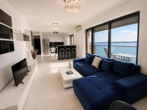 a living room with a blue couch and a television at SOPHIA LAKE VIEW SUITE in Mamaia