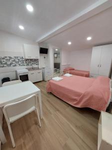 a bedroom with a bed and a table and a kitchen at Arena Vacanze in Castellabate