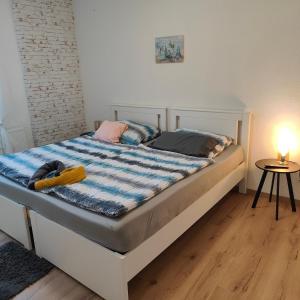 a bed with a blue and white comforter in a room at Ferienwohnung Einsiedler - für 4 Personen mit Terrasse und Grill in Windisch Minihof