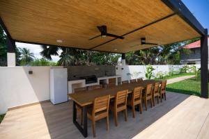 an outdoor dining area with a large wooden table and chairs at Villas 21 in Nosy Be
