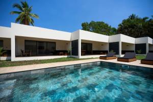 a villa with a swimming pool in front of a house at Villas 21 in Nosy Be +8 photos