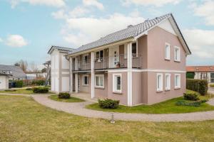 an image of a pink house with a yard at Ückeritz Sylva in Ueckeritz