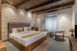 a bedroom with a large bed and a table at Emerald Hill Villa by Jodhani in Udaipur