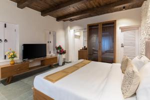 a large bedroom with a large bed and a flat screen tv at Emerald Hill Villa by Jodhani in Udaipur