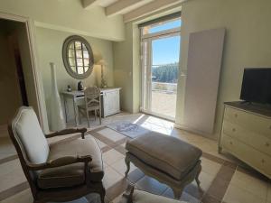 a living room with a chair and a table and a television at Château de Cachard in Boffres