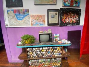 a room with a table with a tv on top at La Mancha Art Hostel - Cerro Alegre - Valparaiso in Valparaíso +29 photos