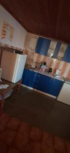 una cucina con mobili blu e un frigorifero bianco di Mizo Apartman a Bar