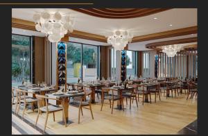 a restaurant with wooden tables and chairs and chandeliers at Aspera Hotel Taksim in Istanbul