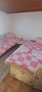 due letti in una stanza con lenzuola rosa e bianche di Mizo Apartman a Bar
