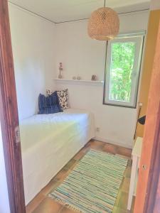 a bedroom with a bed with a window and a rug at Ferienhaus Stensjö in Holmsjö
