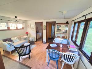 a living room with a couch and a table and chairs at Ferienhaus Stensjö in Holmsjö +13 photos