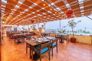 a restaurant with wooden tables and chairs and windows at Xperience Sea Breeze Resort in Sharm El Sheikh