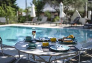 a table with food and drinks next to a pool at Agorastos Luxury Living in Platamonas