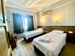 a hotel room with two beds and a window at Sayar Apart in Marmaris +22 photos