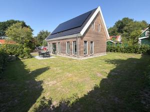 a small house with a solar roof on a yard at Burgvliet41 in Oostkapelle