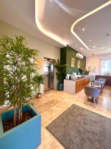 a lobby with a waiting area with potted plants at Tritoni Valletta Boutique Hotel in Il-Furjana