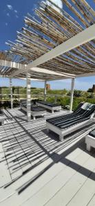 a group of benches sitting on a deck at Frontera Sur Apart in Miramar