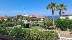 a view of a park with palm trees and cars at Villaliana in Torre Dei Corsari