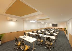a conference room with tables and chairs and a screen at Bloom Hotel Chennai Central in Chennai