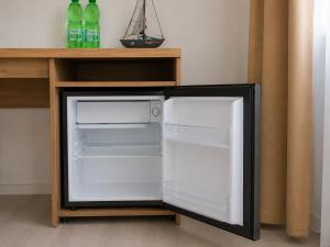 a small refrigerator with its door open on a shelf at Hotel am Seehafen in Hamburg