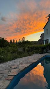 a sunset with a house and a reflection in the water at Madoyans Rest House in Antarut