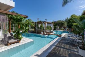 a pool at a hotel with chairs and trees at Agorastos Luxury Living in Platamonas