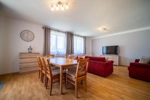 a living room with a table and a red couch at Apartment Riviera 503-8 Lipno Home in Lipno nad Vltavou