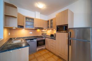 a kitchen with wooden cabinets and a stainless steel refrigerator at Apartment Riviera 503-8 Lipno Home in Lipno nad Vltavou