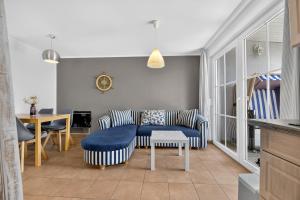 a living room with a couch and a table at Ferienbungalow Malebisa in Loddin