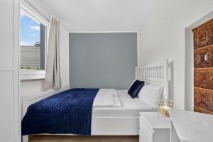 a white bedroom with a bed and a window at Ferienbungalow Malebisa in Loddin