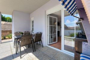 a dining room with a table and chairs on a patio at Ferienbungalow Malebisa in Loddin