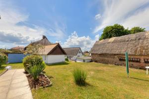 a yard with an old barn and a building at Ferienbungalow Malebisa in Loddin