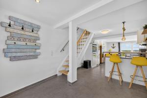 a living room with a staircase and yellow stools at Ferienhaus Malebisa in Loddin
