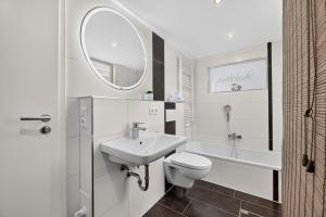 a bathroom with a sink and a toilet and a mirror at Ferienhaus Malebisa in Loddin +18 photos