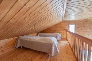 a room with two beds in a wooden attic at Jehkas Huoneisto B in Kilpisjärvi