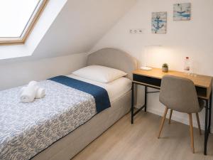 a bedroom with a bed and a desk and a chair at Hotel am Seehafen in Hamburg