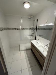 a white bathroom with a sink and a shower at L'estive de Doris in Remollon