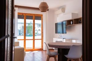 a living room with a table and chairs and a television at Kronos House in Torre del Lago Puccini
