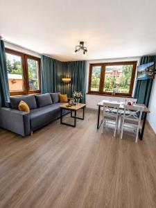 a living room with a couch and a table at Apartamenty Wisła Krzywa 8, wanna z hydromasażem, basen zewnętrzny in Wisła