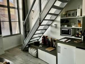 a staircase in a room with a counter and a kitchen at La loge des Salinières in Bordeaux
