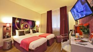 a hotel room with a bed and a flat screen tv at The Originals City - Hôtel Saint-Martial, Limoges Centre in Limoges