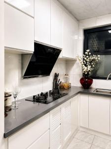 a kitchen with white cabinets and a black counter top at Platinum apartments in Gaborone +13 photos
