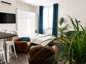 a living room with a bed and some plants at Beautifully Bright Apartment in Old Town Saint-Tropez in Saint-Tropez