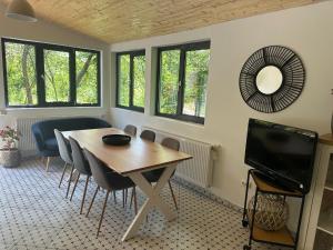 a dining room with a table and a tv at Acasa la Coana Mare in Bălăneşti