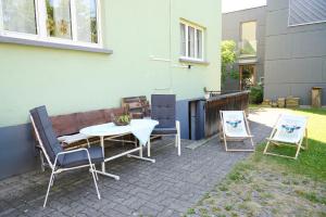 a patio with a table and two chairs and a building at Zimmervermietung Jäger in Bregenz