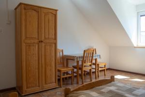 a dining room with a table and chairs and a cabinet at Agroturystyka Nad Hańcza in Błaskowizna