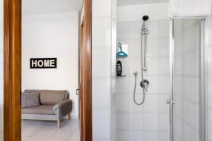 a bathroom with a shower with a chair and a couch at La Rosa Blu Vacation Home in Sanremo +13 photos