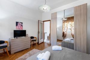 a bedroom with a bed and a television in a room at La Rosa Blu Vacation Home in Sanremo