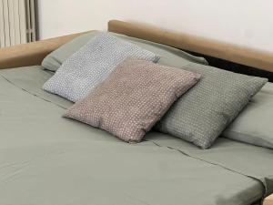 a bed with three pillows on top of it at La casa di AngeLis in Stezzano