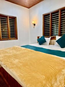 a bedroom with two beds and two windows at Ira Homestay in Sringeri